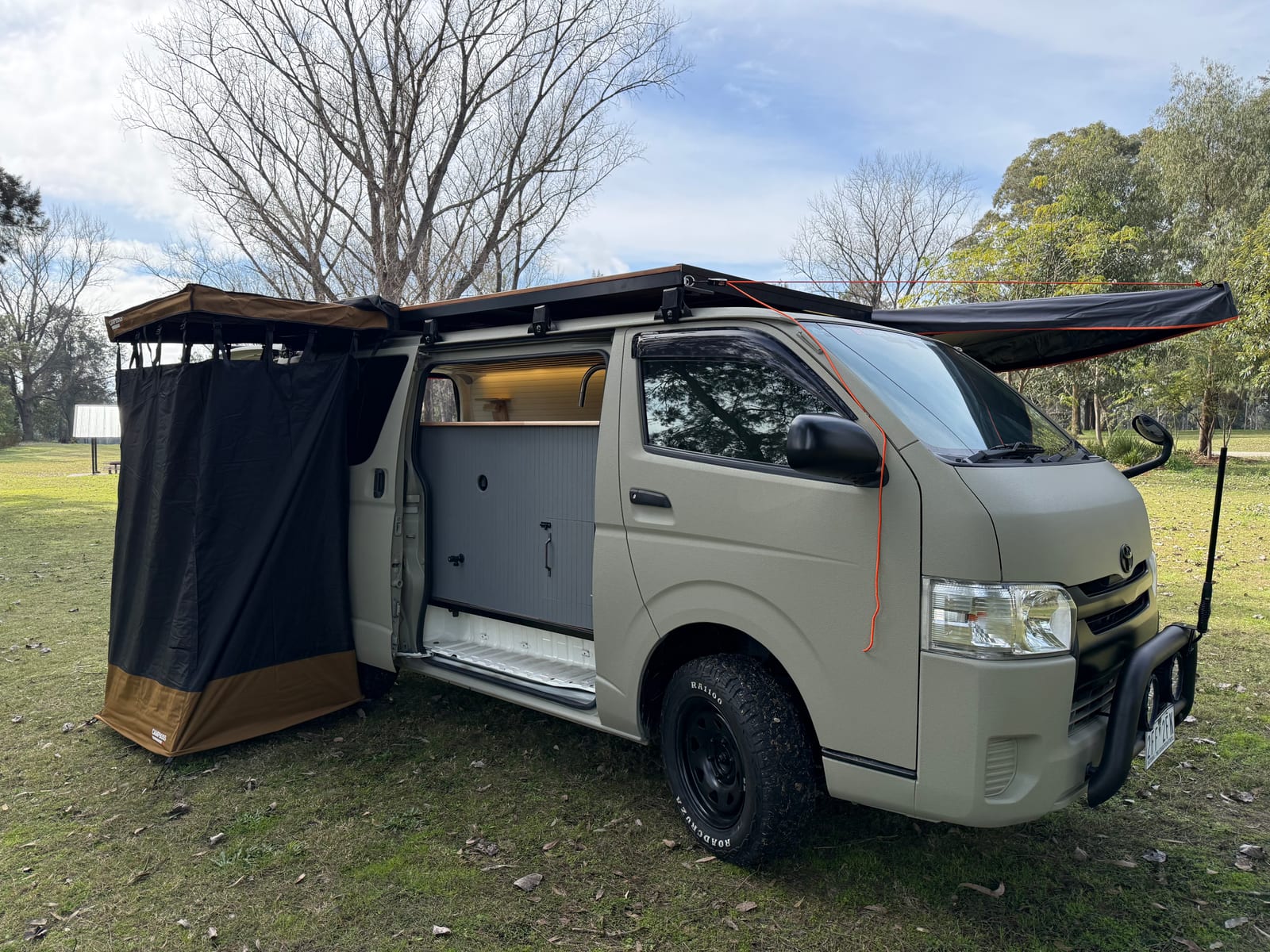 Khaki 4×4 Hiace — Ensuite tent up against the side door