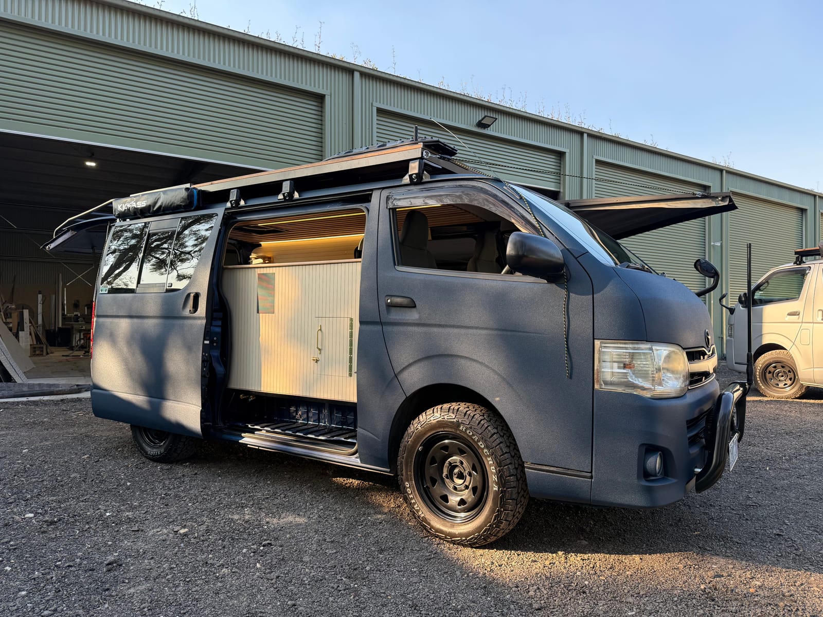 Navy 4×4 Hiace — Front three-quarter at the workshop
