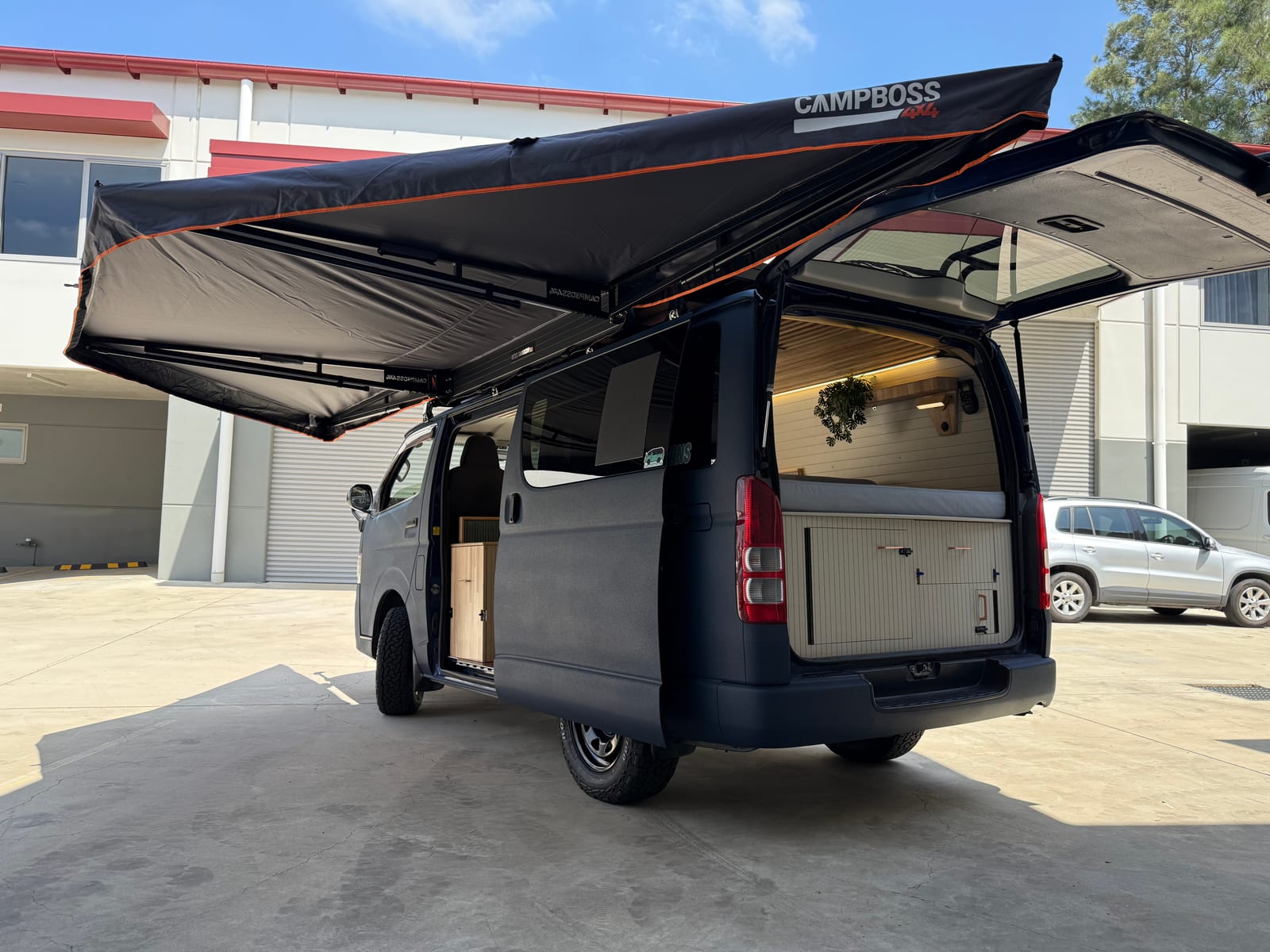 Slate Blue Hiace — Side on, awning fully extended