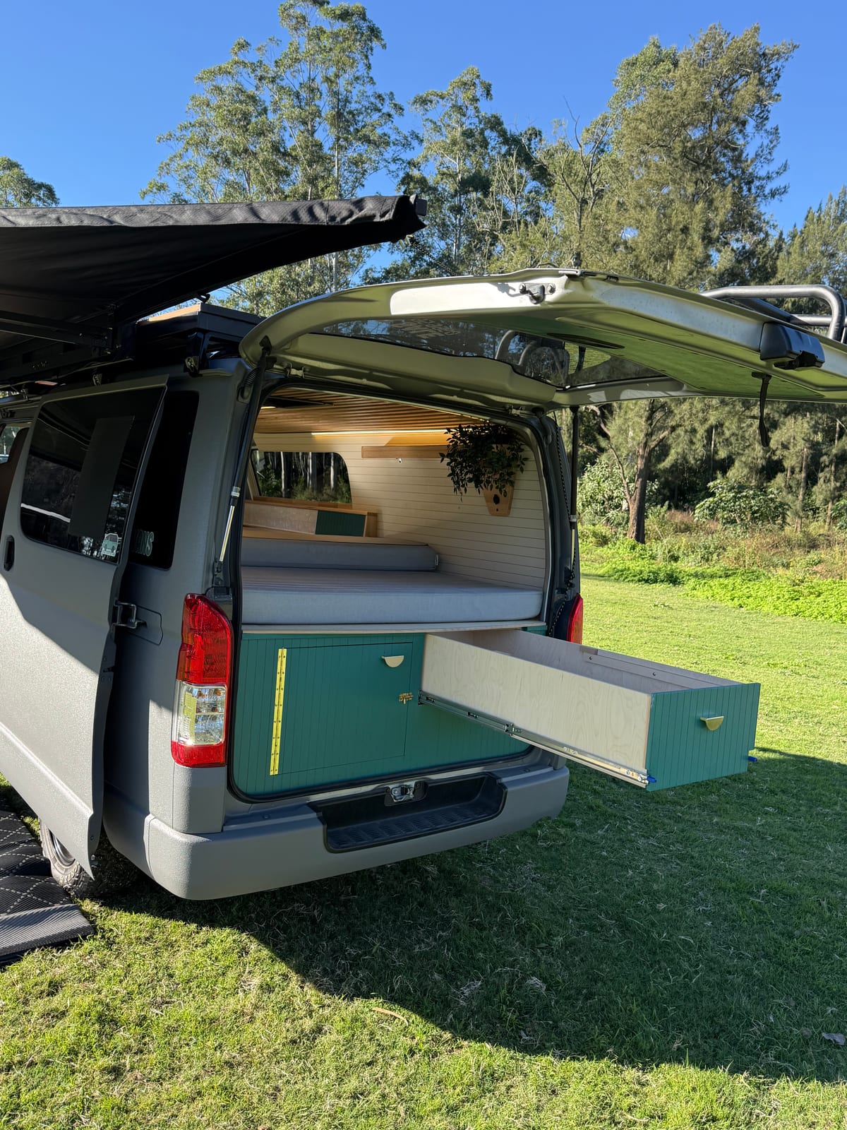 Teal Galley Hiace — Rear quarter under the awning