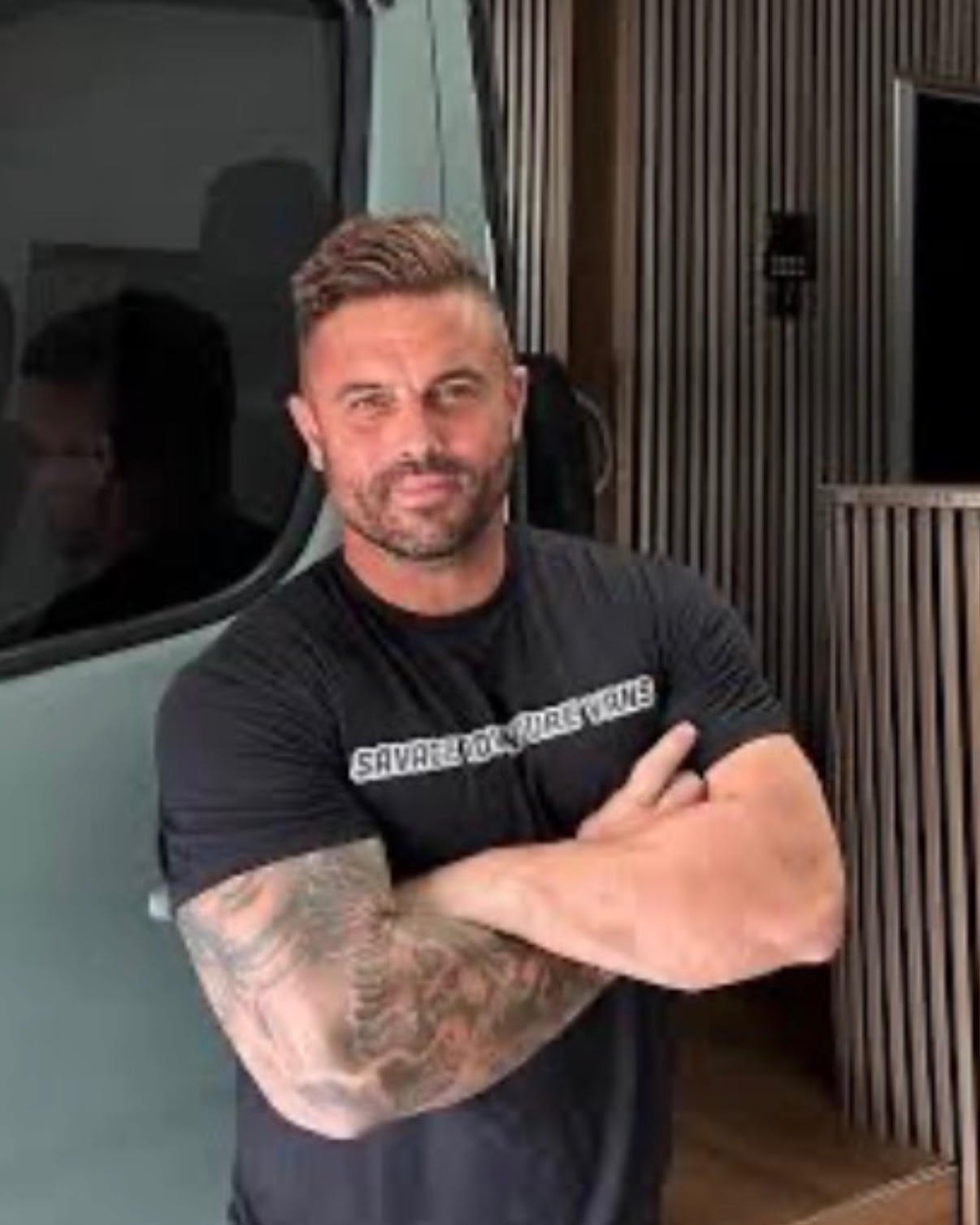 Reece Savage, owner of Savage Adventure Vans, standing beside a van build